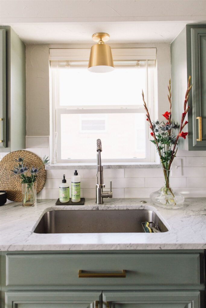 Green painted cabinets with marble countertops