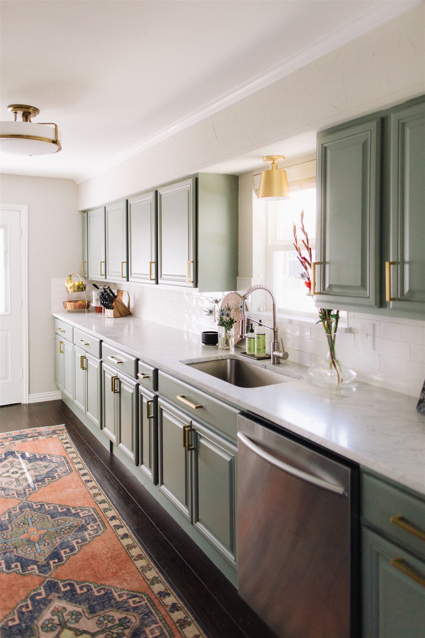 Green kitchen cabinets with vintage turkish rug