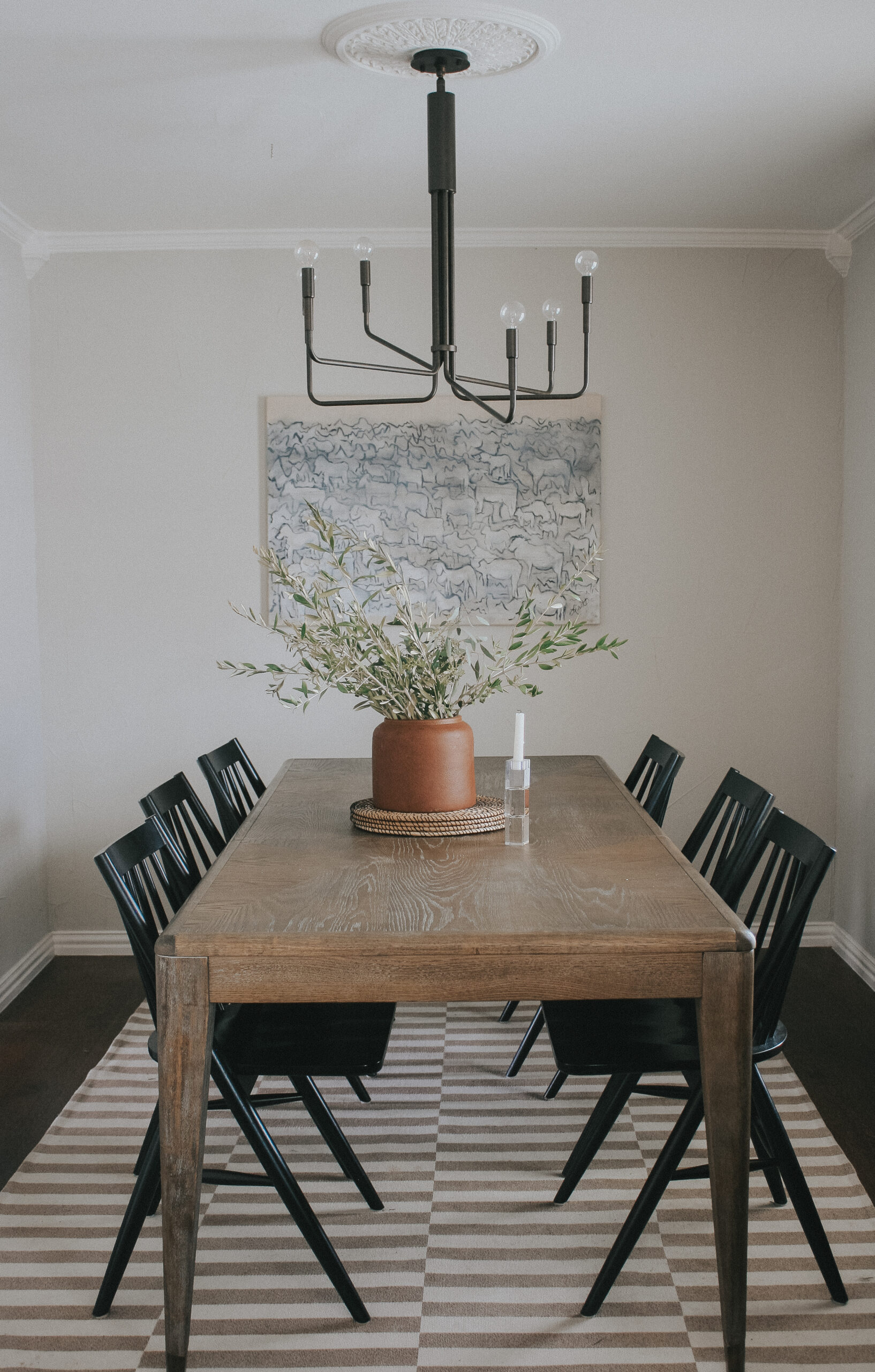 Dining room with neutral rug and modern light fixture