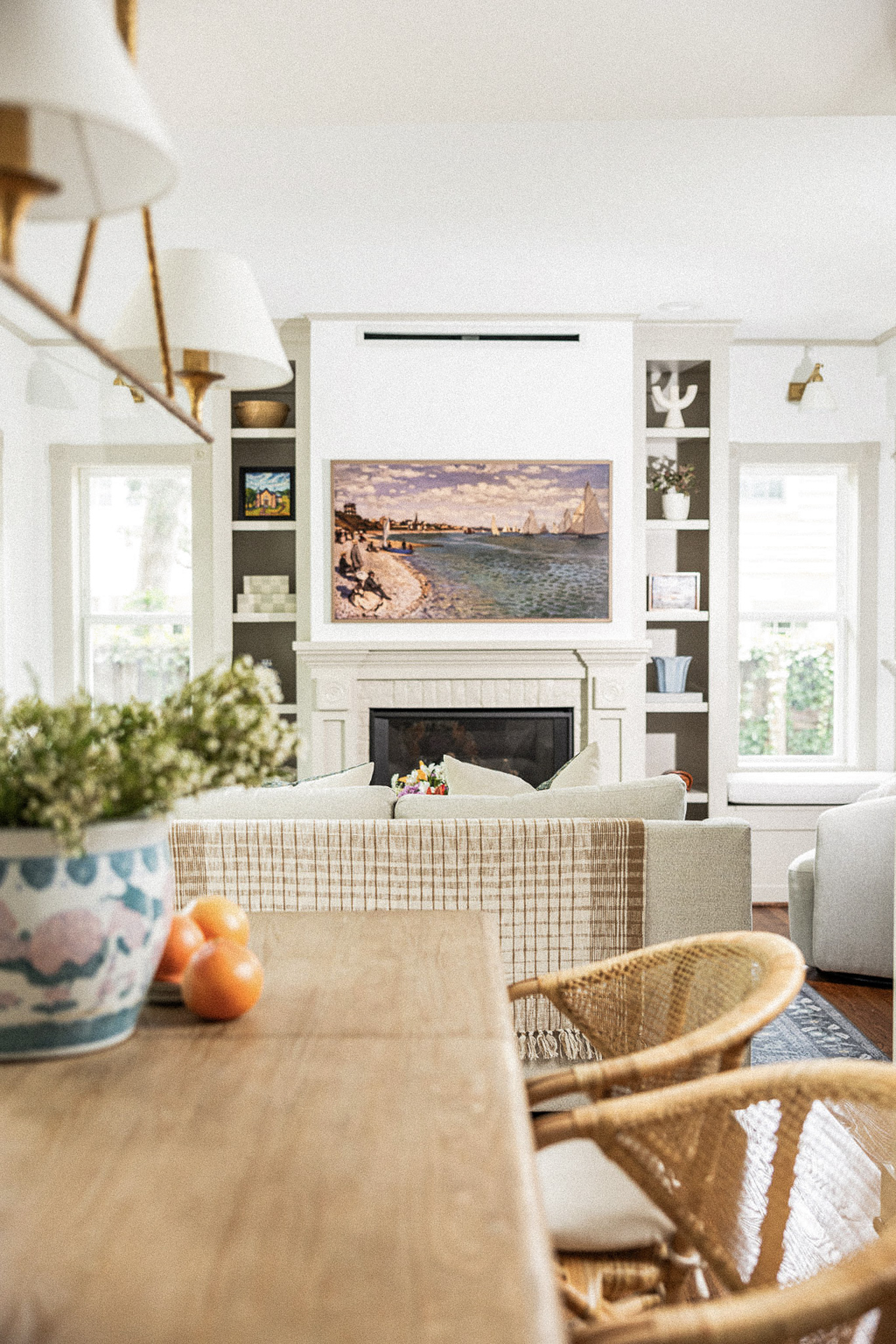 Dining room with farmhouse table and rattan chairs flowing into a cozy living room